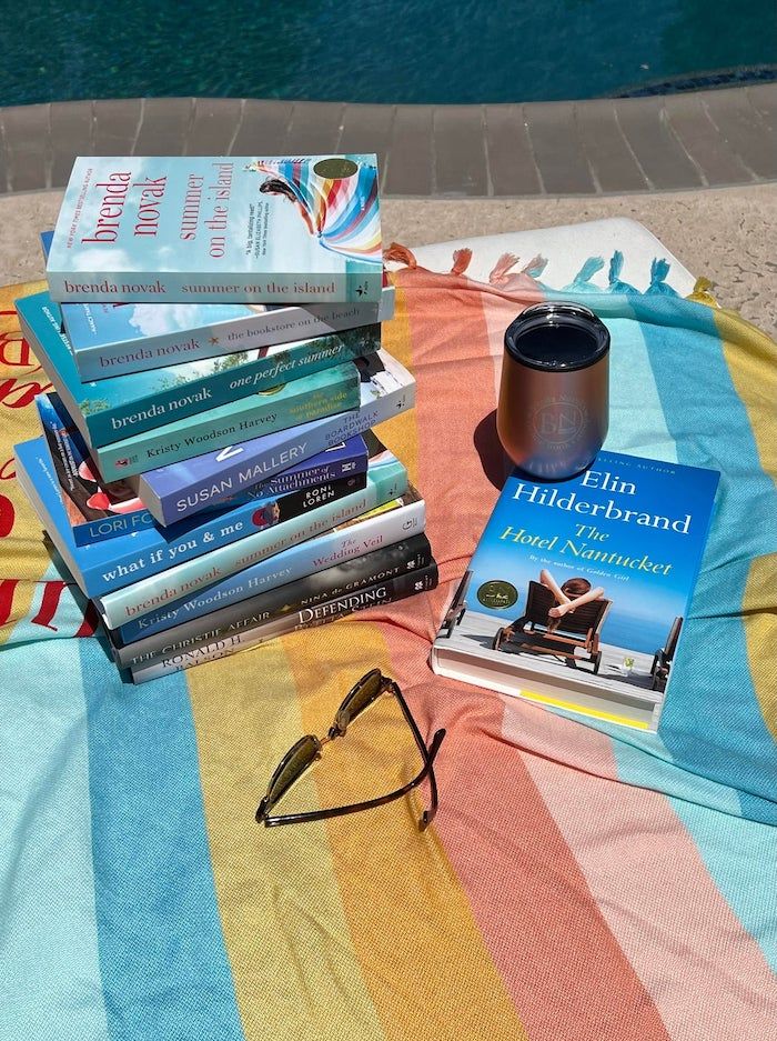 pile of books on a striped beach blanket
