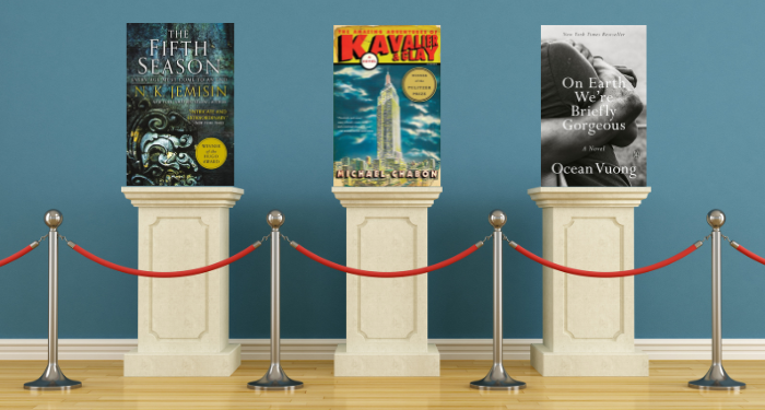 the covers of three queer books on podiums behind a velvet rope