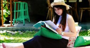 fair-skinned Asian woman reading on the lawn