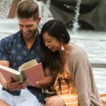Asian woman and white man reading together