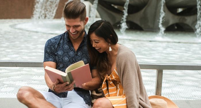 Asian woman and white man reading together