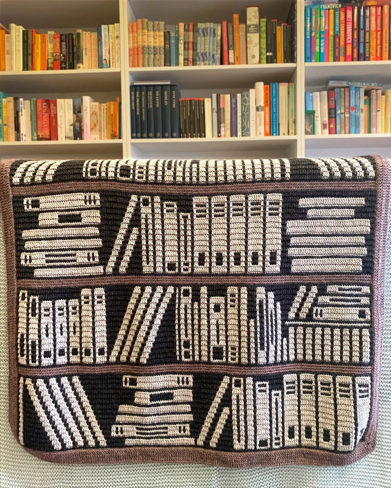 a crocheted blanket with an image of a bookcase