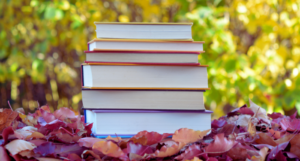 stack of books in a pile of leaves