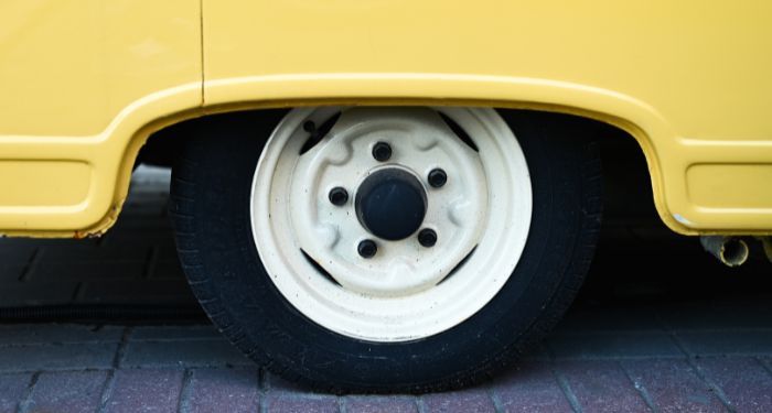 closeup of one wheel of a yellow van