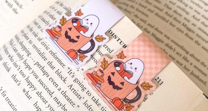 magnetic bookmark of a reading hosts in a jack-o-lantern mug